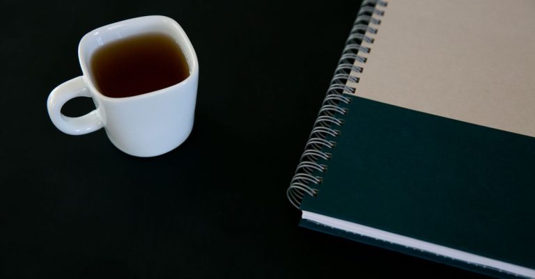 A tutor's desk with a payment ledger notebook and a phone showing a message.