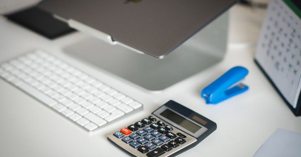 Lesson credit ledger basics: a tidy notebook with handwritten columns for credits beside a laptop.