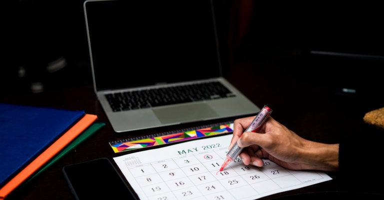 A tutor checking a calendar of confirmed lessons beside a phone with reminder messages.